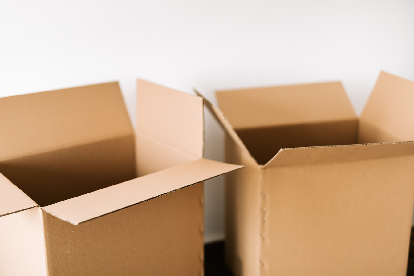 Cardboard boxes on dark surface against white wall